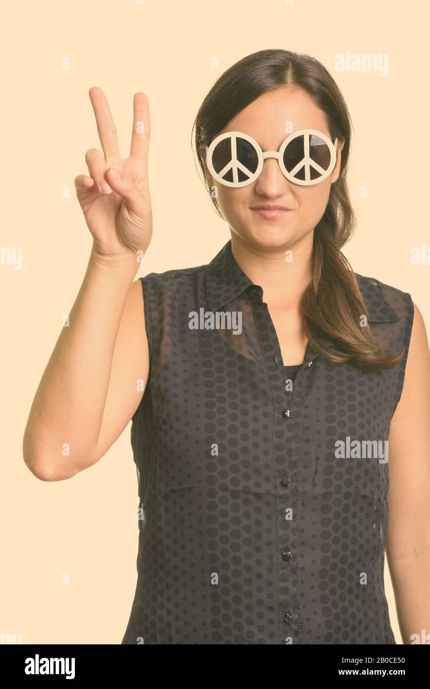 Close up di bella donna che indossa gli occhiali da sole con segno di pace e dare la pace segno gesto Foto Stock