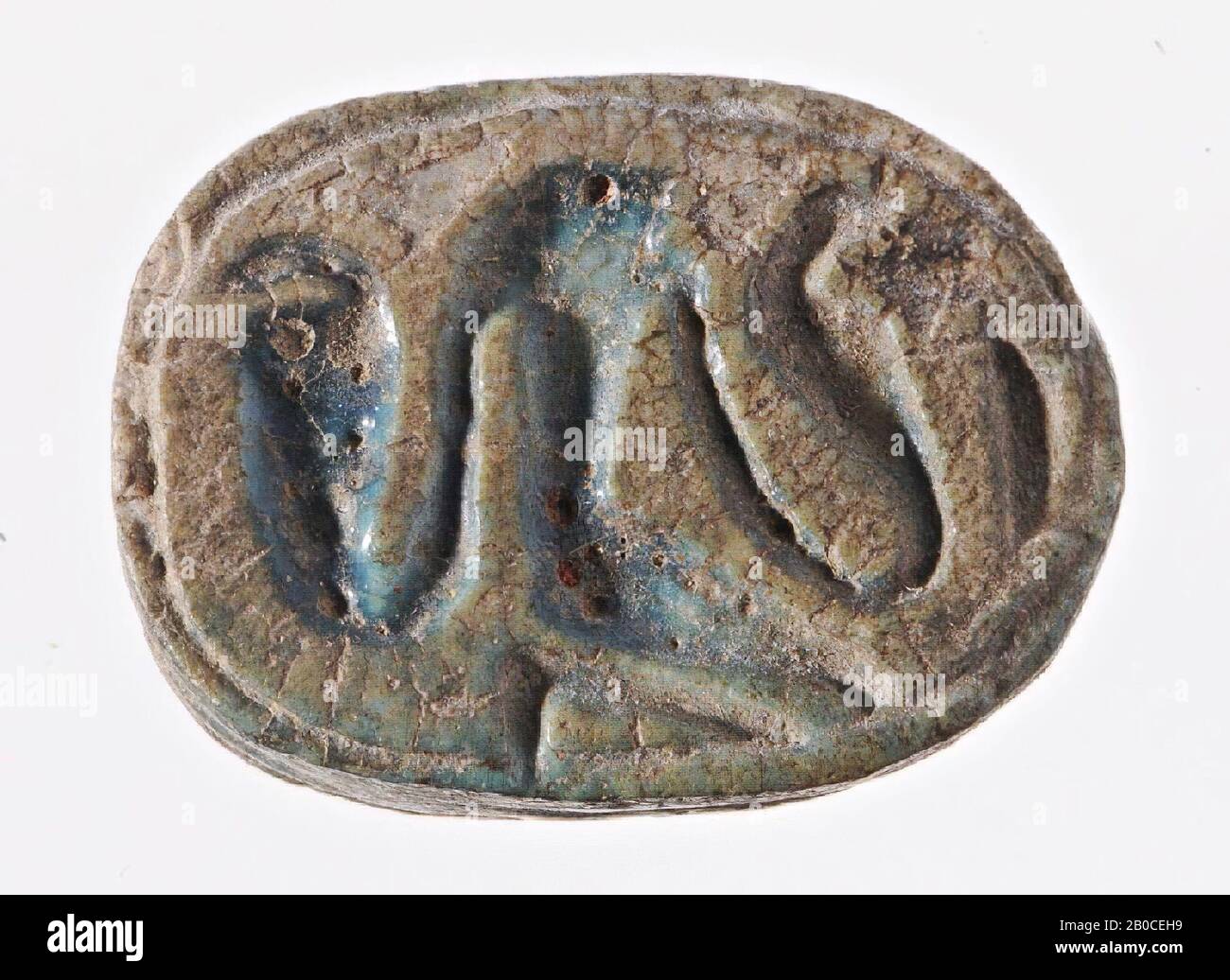 Scarabeo, Re, inginocchiato, ureo, il sigillo ha la forma di una sciarpa stilizzata. La testa triangolare scanalata con piccolo clypeus è separata dal corpo altrimenti non suddiviso da una linea dentellata. Tuttavia, una scanalatura che si estende longitudinalmente è prevista su entrambi i lati della spina dorsale. Il coleottero è separato dalla sua base ovale da una scanalatura doppia che corre tutto intorno. Questa base funziona anche come una superficie di tenuta, in cui un dio di inginocchiamento con testa di falco è rappresentato all'interno di una scanalatura ovale di incorniciatura. Le sue braccia appese verso il basso vanno ciascuna in un tubo verticale e eretto uraeus. A destra il tutto è delimitato da un Foto Stock