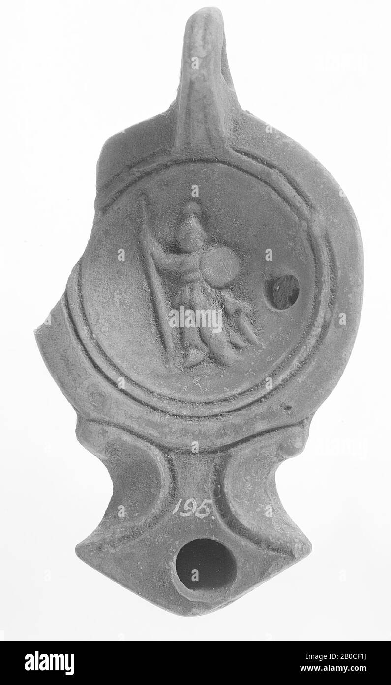 Lampada ad olio verniciato rosso con corpo rotondo. Lo specchio concavo è circondato da cerchi concentrici ed è decorato con un'immagine in rilievo di Athena con una lancia in uno, uno scudo nell'altra mano. Il piccolo foro di riempimento è a destra della figura. Il beccuccio corto e largo con un piccolo foro per il fuoco è incorniciato da volute. L'orecchio è disposto verticalmente e dentellato, lampada ad olio, terracotta, terracotta, 4 x 10 x 5,8 cm, 2nd secolo ad. 100-200, Tunisia Foto Stock
