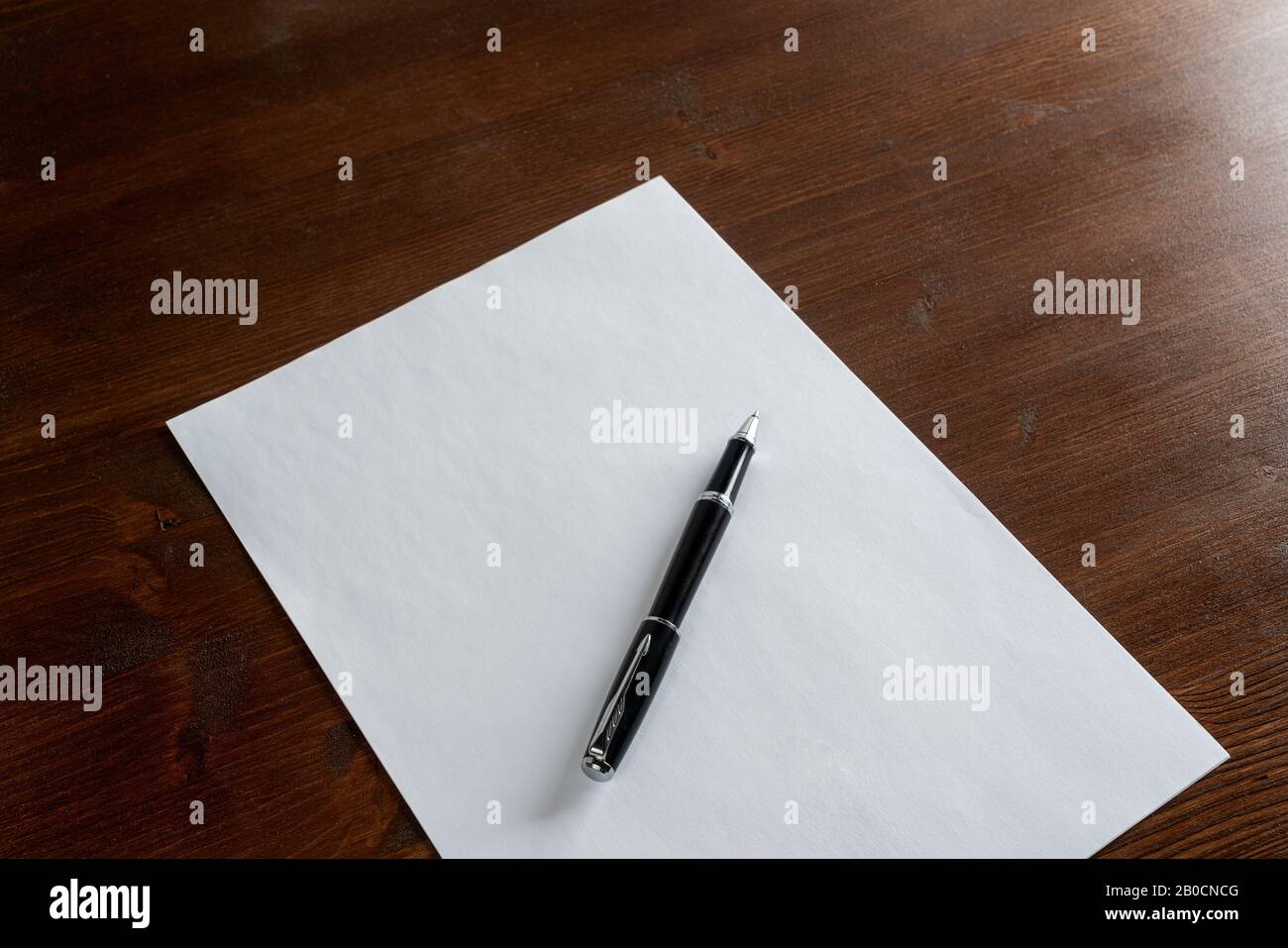 una penna appoggiata su un foglio di carta bianco Foto Stock