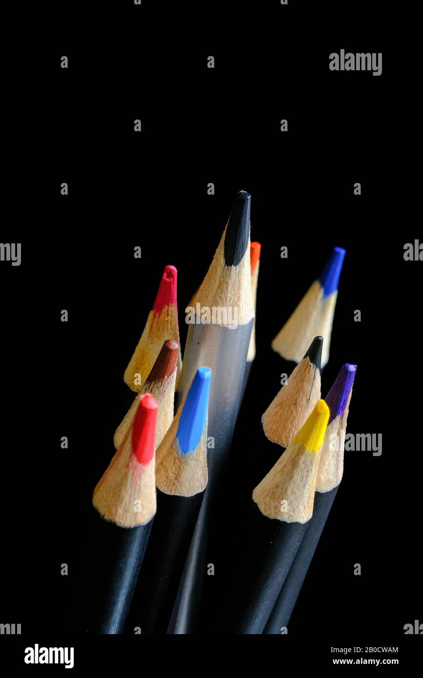 Set di matite colorate con una matita nera che si alza sopra e si alza dagli altri Foto Stock