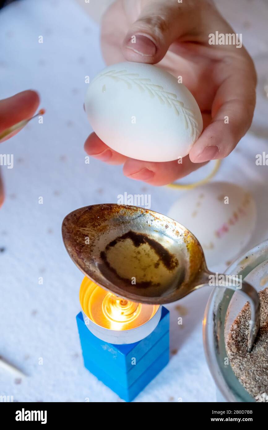 Le mani femminili dipingono un uovo di Pasqua secondo la tradizione sorbiana con una testa d'ago e cera di candela fusa. Foto Stock