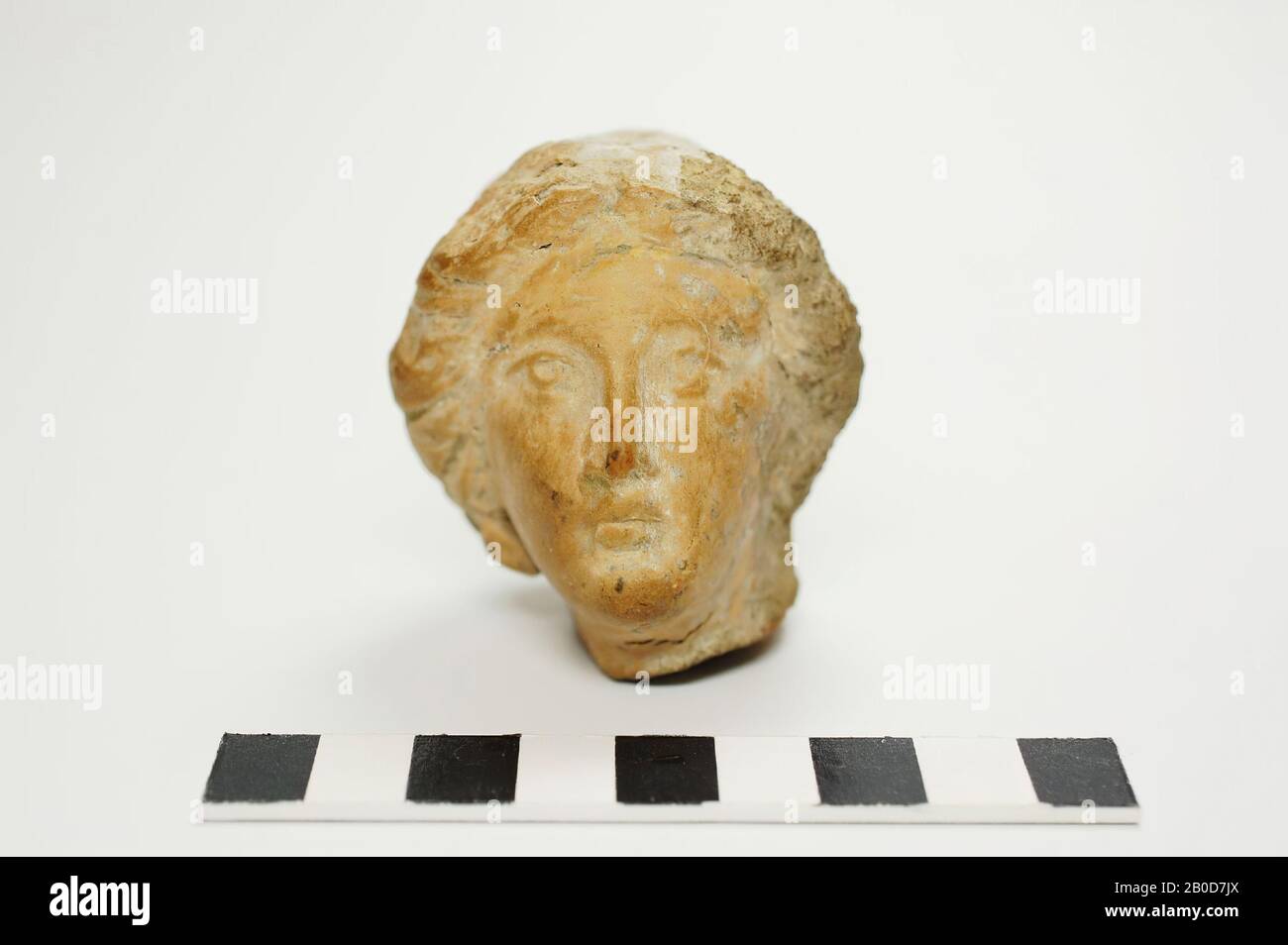 Coppa di terracotta di una giovane donna, ispirata ai ritratti di Alessandro Magno. Il classico viso greco presenta occhi straordinariamente grandi, con la pupilla che si diresse drammaticamente verso il cielo. Capelli molto lavorati che è stato modificato sudicio sul retro con una spatola. Hol. La tazza è cotta molto dura, che si oppone ad una data nell'antichità. E' possibile che il volto classico con una muffa sia stato copiato in un ritratto di Alessandro Magno: Le caratteristiche fini del viso contrastano molto bene con l'acconciatura sloppy con tracce spaziali. L'argilla ha un odore duro, chimico, diverso di quelli antichi Foto Stock