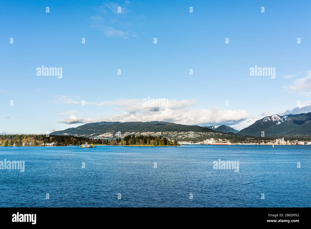Vancouver, British Columbia, Canada - Dicembre, 2019 - Vista sulle montagne con nuvole in una Splendida giornata di cielo blu al porto marittimo della costa occidentale. Foto Stock