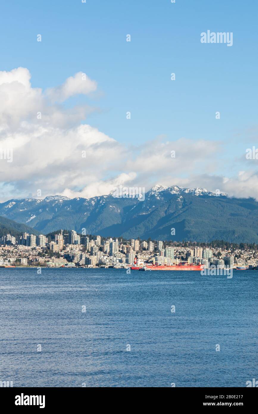 Vancouver, British Columbia, Canada - Dicembre, 2019 - Vista sulle montagne con nuvole in una Splendida giornata di cielo blu al porto marittimo della costa occidentale. Foto Stock