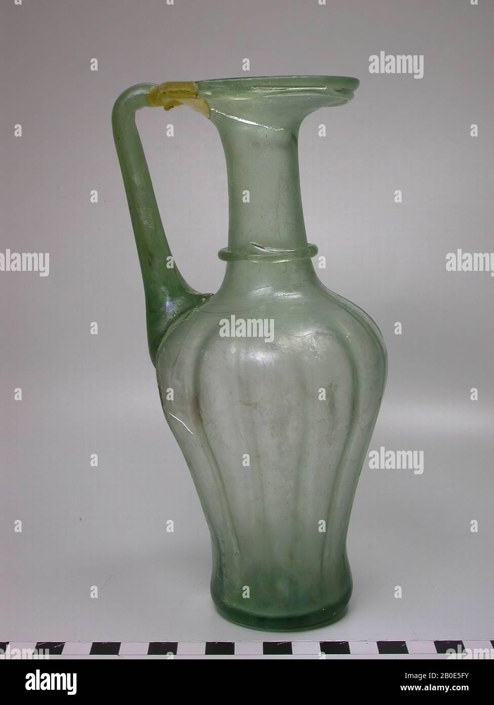 Caraffa in vetro verde chiaro con collo stretto, ampia bocca a forma di disco e orecchio. Intorno al collo decorato con un unico filo di vetro. Il ventre è costolato e corrugato, stoviglie, vetro, H 20 cm, Libano Foto Stock