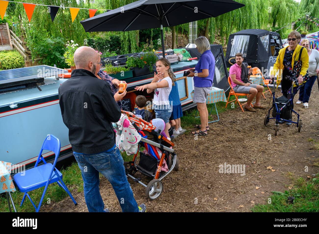 Persone sul canale alzaia visitare Gnosall Canal Festival in un pomeriggio di estati. Visitatori che guardano barche ormeggiate e acquistare beni da commercianti. Foto Stock