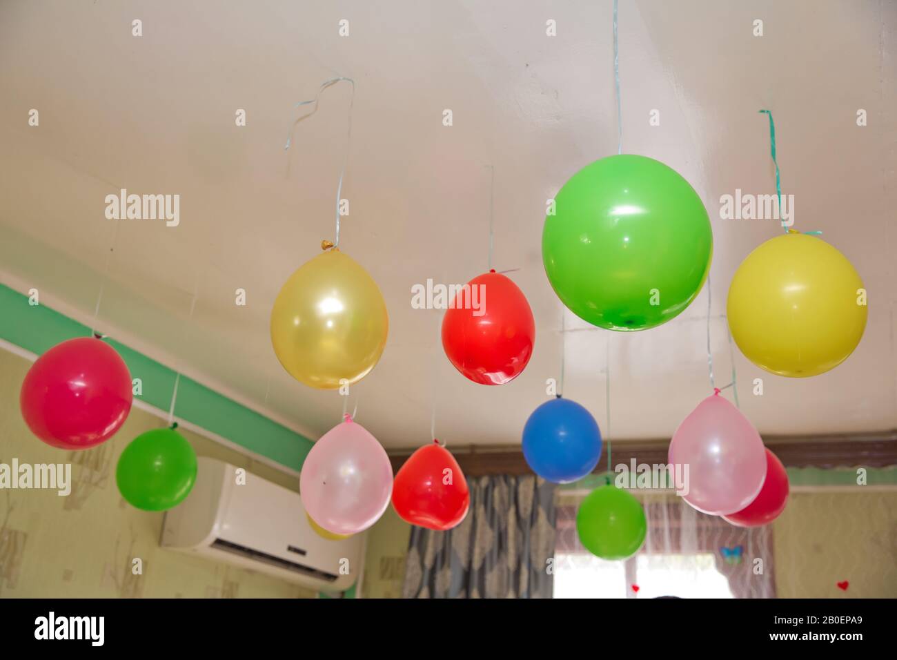 Palloncini di elio . I palloncini colorati e rossi galleggiano sul soffitto  bianco nella stanza per la festa. Matrimonio o bambini compleanno  decorazione inter Foto stock - Alamy