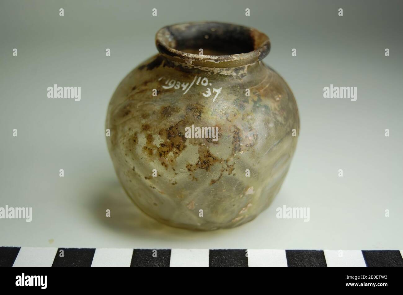 Vaso, Forma soffiato vaso di vetro trasparente decolorato, probabilmente islamico. Il vaso ha un corpo sferico molto irregolare con una decorazione di 14 doppi vetri goffrati intorno ad esso. In basso è stata premuta una stella a cinque punte con un punto centrale. Il vaso ha una bocca larga con un bordo leggermente arrotondato., Pot, vetro, stampo soffiato, h. 5,4 cm, diam. 5,5 cm, Periodo copto 9th-10th Secolo, Egitto Foto Stock
