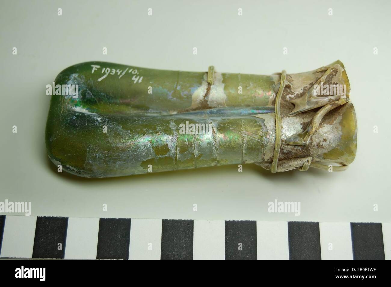 Balsamario doppio, balsamario doppio di vetro verde trasparente. La bottiglia ha due scomparti cilindrici, prima leggermente rastremati e alla bocca ancora leggermente uilopend e un fondo spesso-murato con marchio del pontil. La bottiglia è decorata con un unico filo di vetro che è zigzagged cinque volte intorno alla bocca e sette volte intorno al corpo. Manca la decorazione del filo di vetro., Bottiglia, bottiglia doppia, vetro, soffiato, filetti di vetro, h. 9,7 cm, b. 4,4 cm, periodo greco-romano, epoca imperiale romana 4th-5th Secolo, Egitto Foto Stock