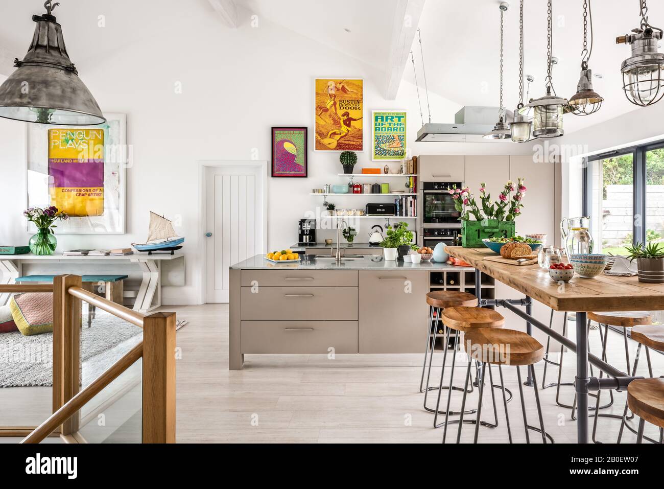 Luci rinnovate sopra il bar della colazione con opere d'arte in stile 1960s in lavori di ristrutturazione della cucina a pianta aperta Foto Stock