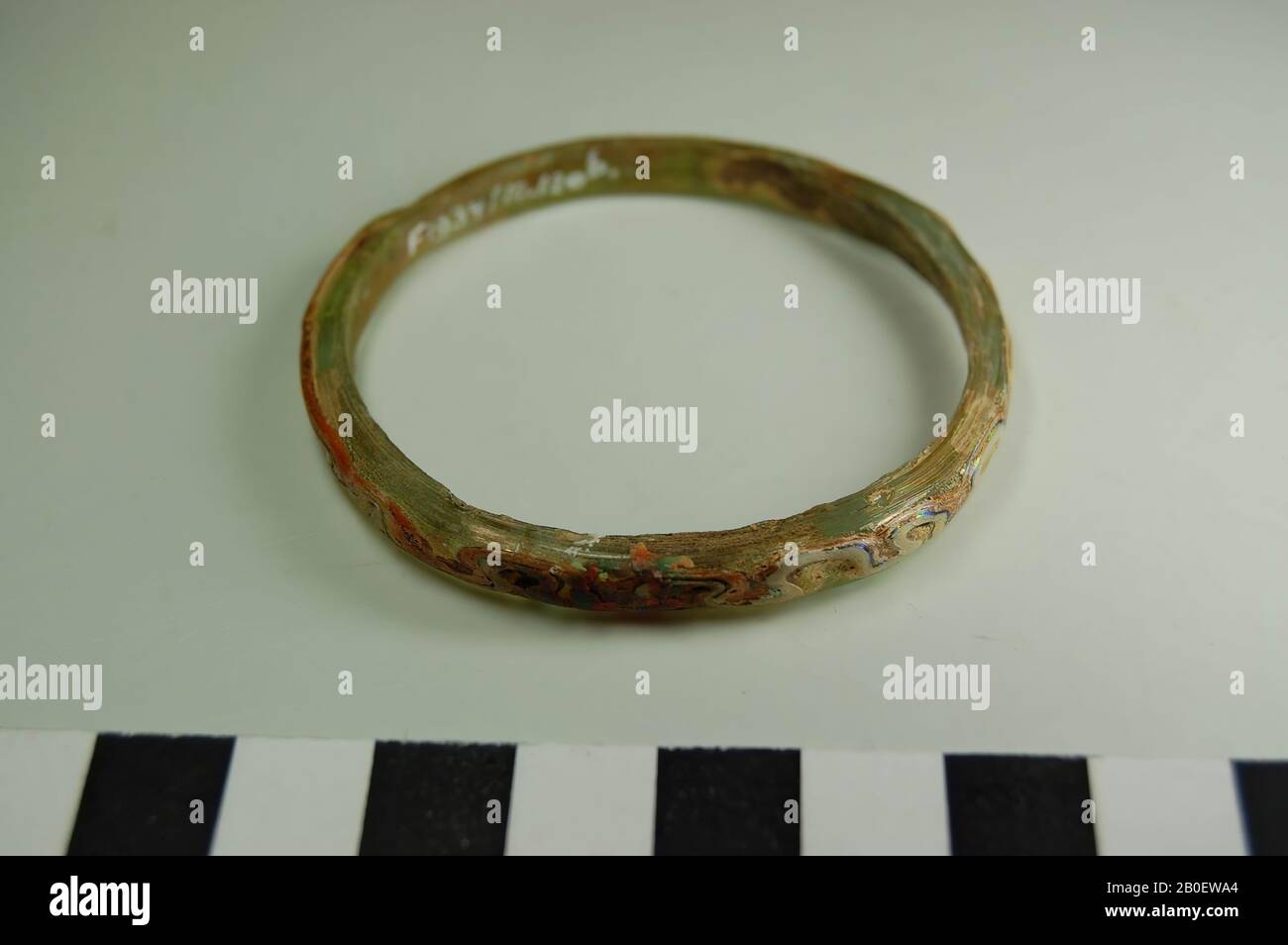 Bracciale, un bracciale rotondo irregolare in vetro trasparente verde chiaro. Decorato con un filo di vetro fuso meandering di vetro opaco nei colori nero, bianco, giallo e arancione., bracciale, vetro, filo di vetro manipolato, diam. 5,9 cm, Periodo copto, 3rd Secolo islamico, Egitto Foto Stock