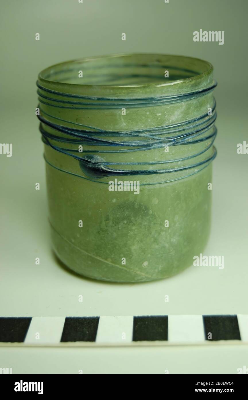 Coppa, bicchiere di vetro verde oliva con decorazione di fili di vetro blu scuro. La tazza ha un corpo cilindrico con un fondo concavo e un'anima a forma di cono. La metà superiore della tazza è decorata con un unico filo di vetro avvolto intorno al corpo più volte., tazza, vetro, liberamente soffiato, fili di vetro, h. 6,7 cm, diam. 5,9 cm, Periodo copto, islamico 5th-10th Secolo, Egitto Foto Stock
