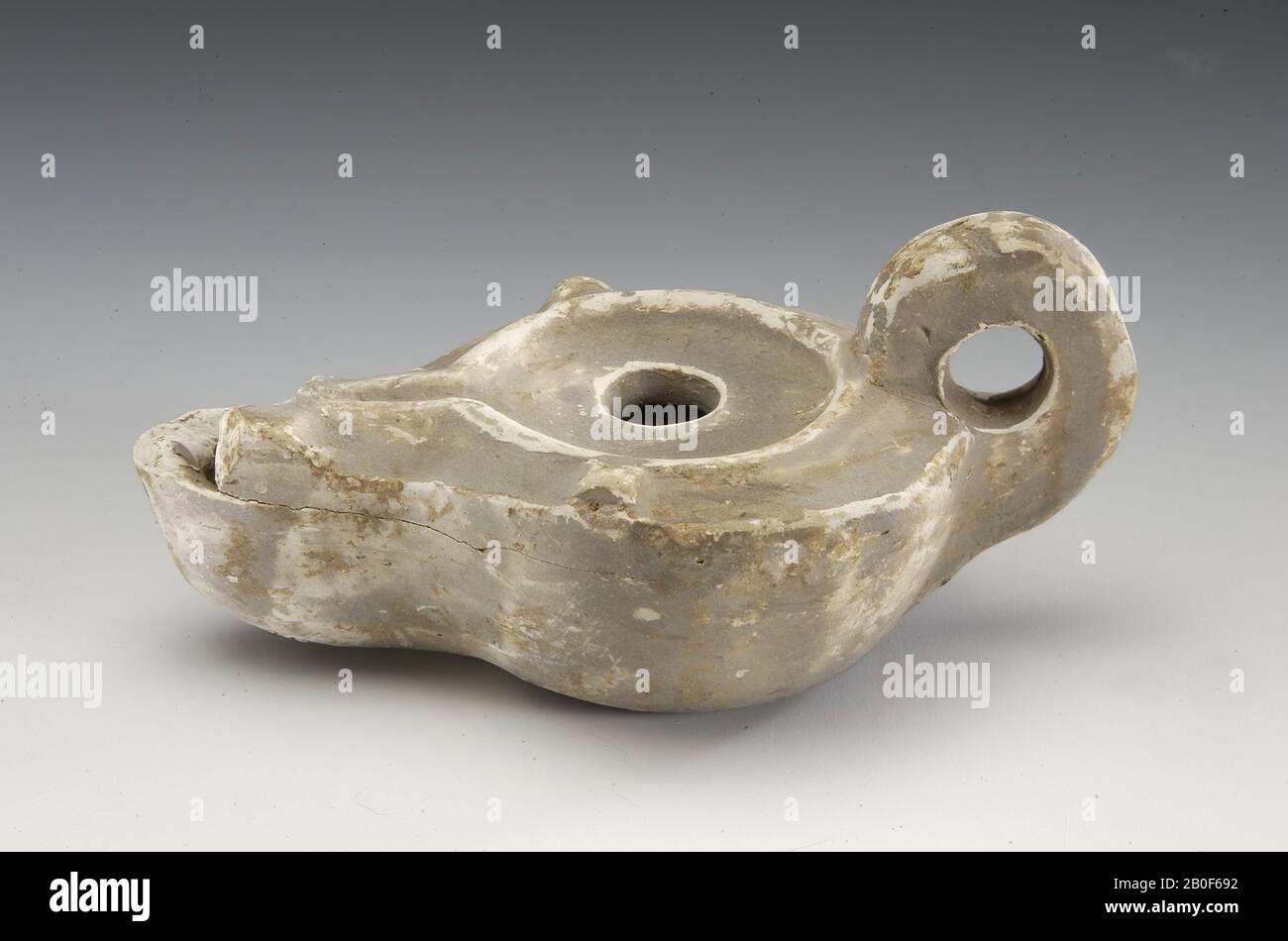 Lampada di terracotta, Loeschcke tipo X, con engem Kanal (255 (67)). Parte superiore tuit danneggiata. Senza anello di supporto, colorato in grigio. Sotto il fondo molto vagamente un timbro. Al centro forse una lettera o, tutti insieme solo 3 lettere. Wrsch. QGC, Leibundgut Taff. 13, 909. Nessuna traccia d'uso, nessuna traccia d'incendio., lampada ad olio, ceramica, h: 7 cm, roman 100-200 ad, Olanda, Limburgo, Heerlen, Heerlen Foto Stock