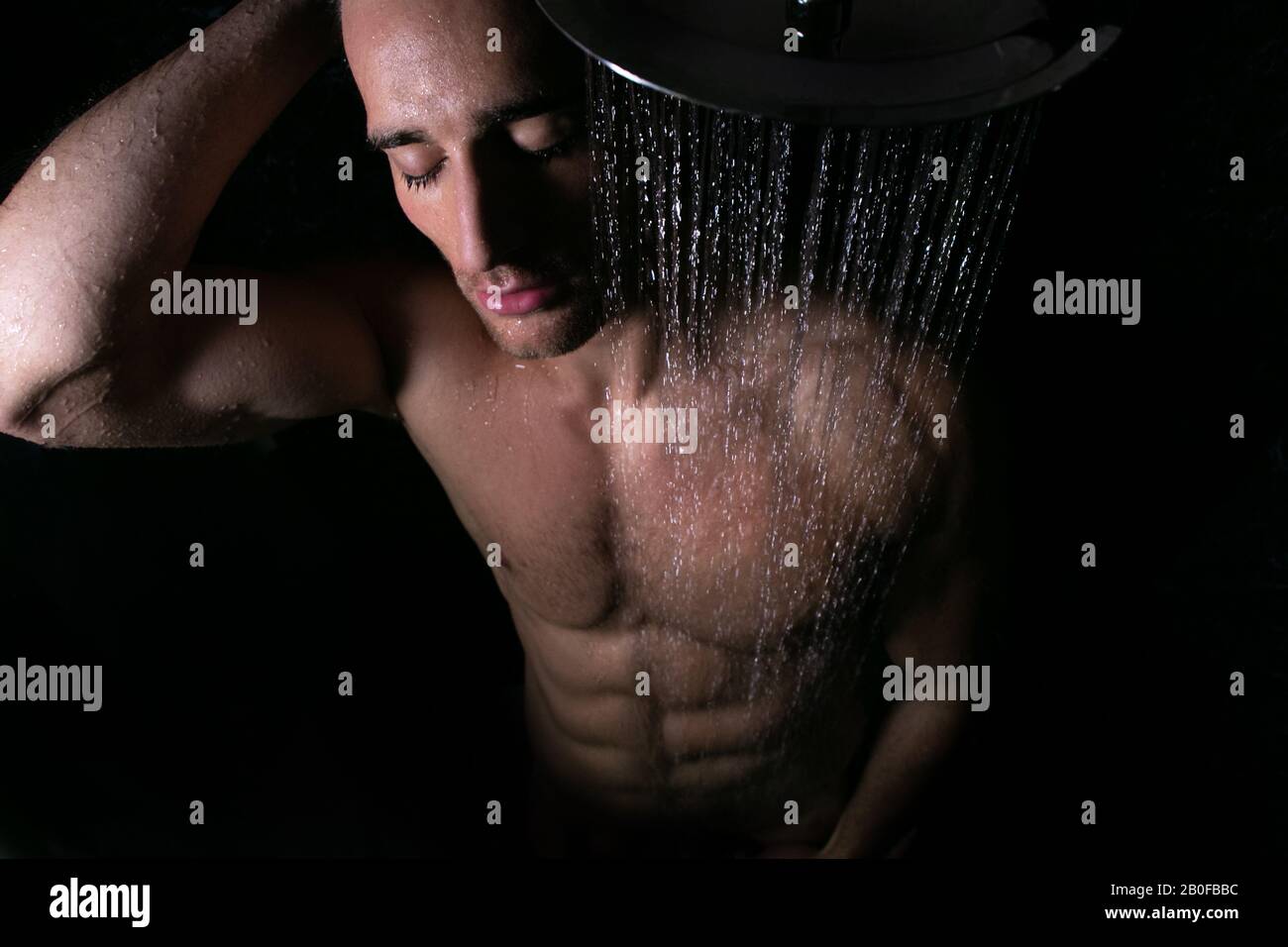 Ritratto sexy di uomo nudo muscoloso con pecs e sixpack abs sotto doccia a  pioggia con occhi chiusi Foto stock - Alamy