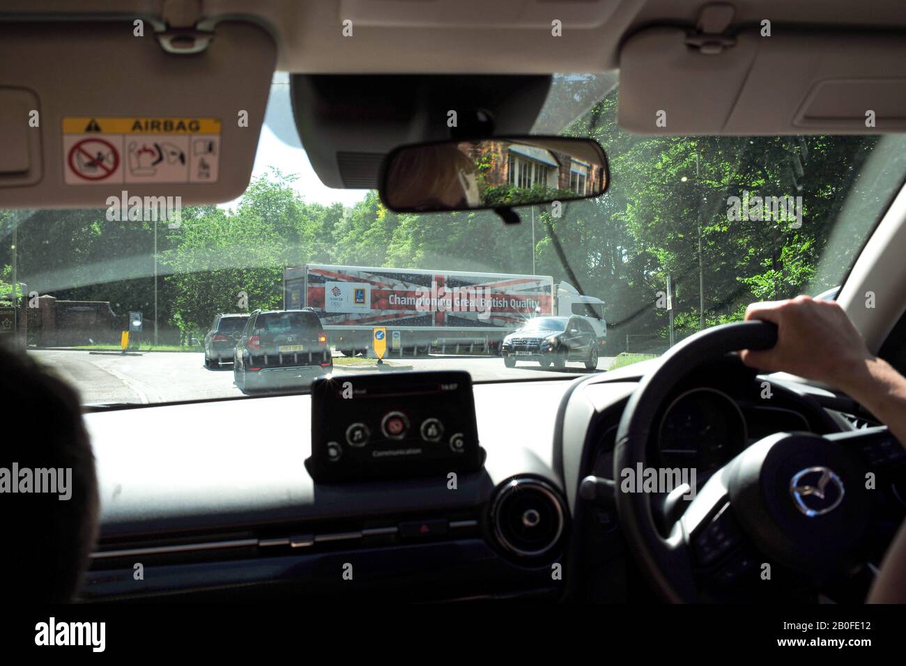 Una vista di un camion Aldi Supermarket con una bandiera Union Jack sul rimorchio che fa pubblicità alla qualità britannica vista dall'interno di un automobile. Foto Stock