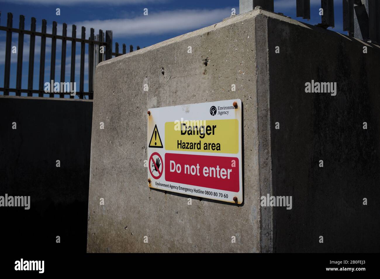 Un cartello di pericolo per l'area dall'agenzia ambientale sulle tubature di scarico dell'acqua che conducono al mare a Lepe Beach Hampshire. Foto Stock