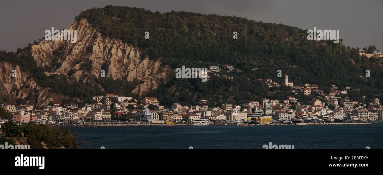Una lunga vista del porto della città di Zante che mostra gli edifici e il porto dominato dalle scogliere calcaree dominanti. Foto Stock