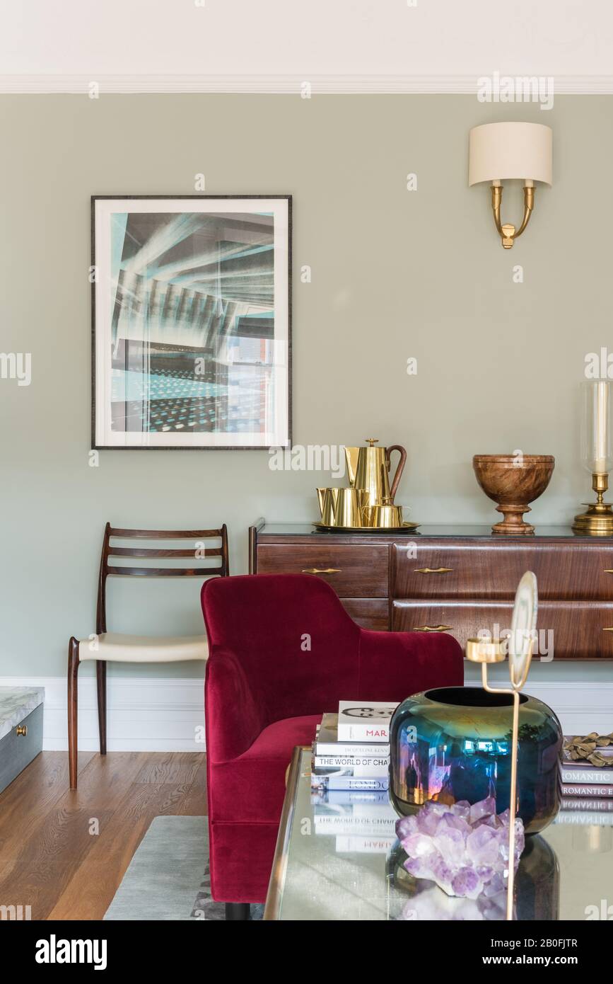 Mix di pezzi vintage e contemporanei, sideboard Yoko e poltrona su misura in velluto rosso Foto Stock