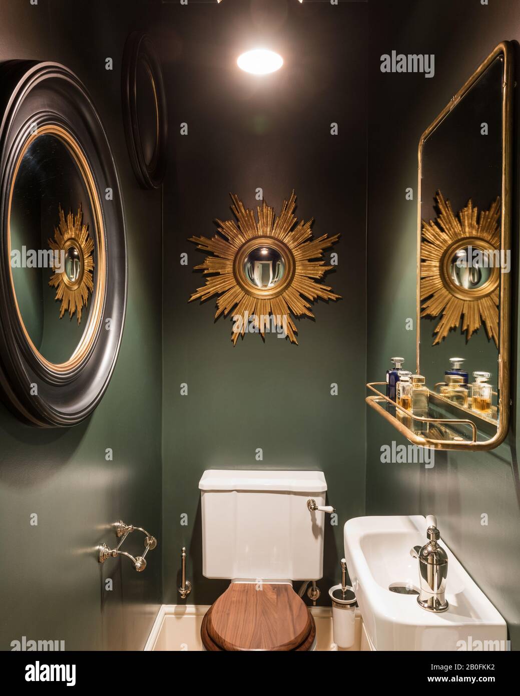 Bagno verde con specchi vintage che danno idea dello spazio Foto Stock