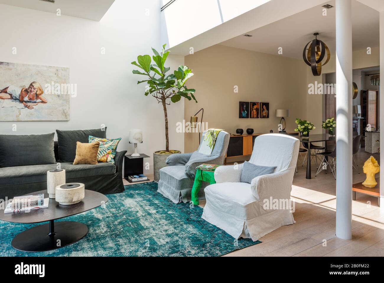 Alto lucernario in estensione di casa terrazza con tappeto vintage overtinto, sedie e grande impianto domestico Foto Stock