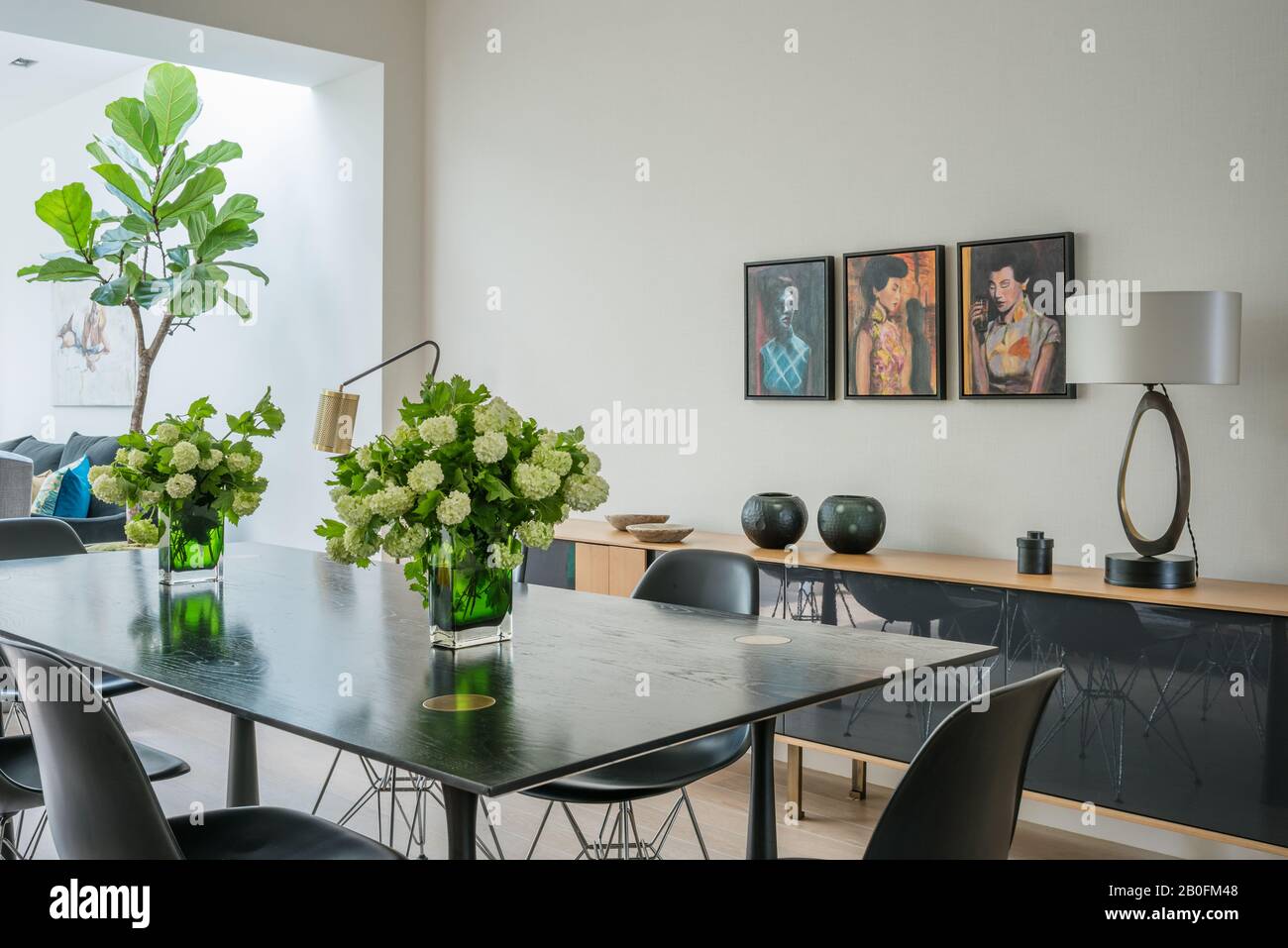 Tavolo da pranzo in rovere colorato Ebony su gambe in bronzo con sponda Molteni e ornamenti Foto Stock
