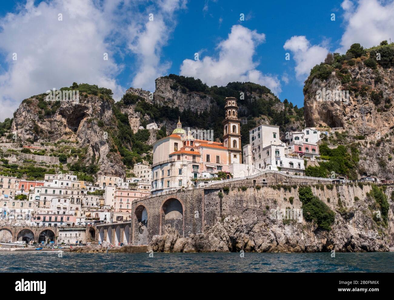 Il paese di Atrani e la Collegiata di Santa Maria Maddalena vista dall'acqua, dalle montagne e dal cielo sullo sfondo, sulla Costiera Amalfitana d'Italia Foto Stock