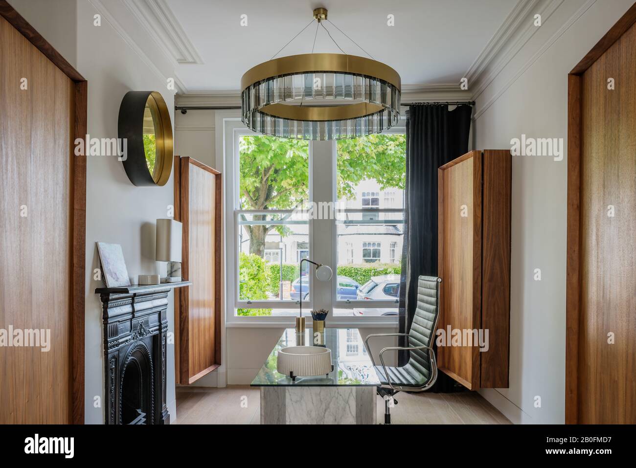 Clare Turner pensili appesi a parete in noce americano con lampada Columbo sul pannello di copertura, lampada vintage Array su scrivania e plafoniera circolare Solaris, Foto Stock