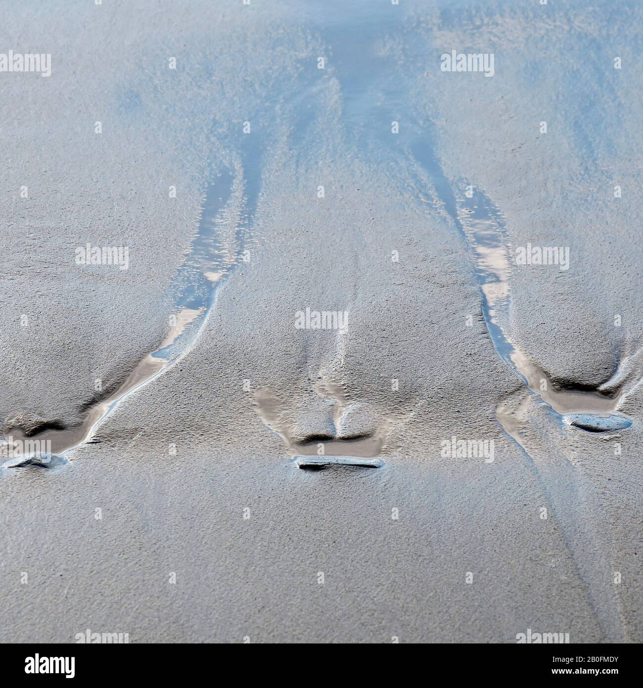 Astratto dettagliato tidal modelli e blu cielo riflessioni nella sabbia a bassa marea sulla spiaggia Penbryn nel sud ovest del Galles UK Foto Stock