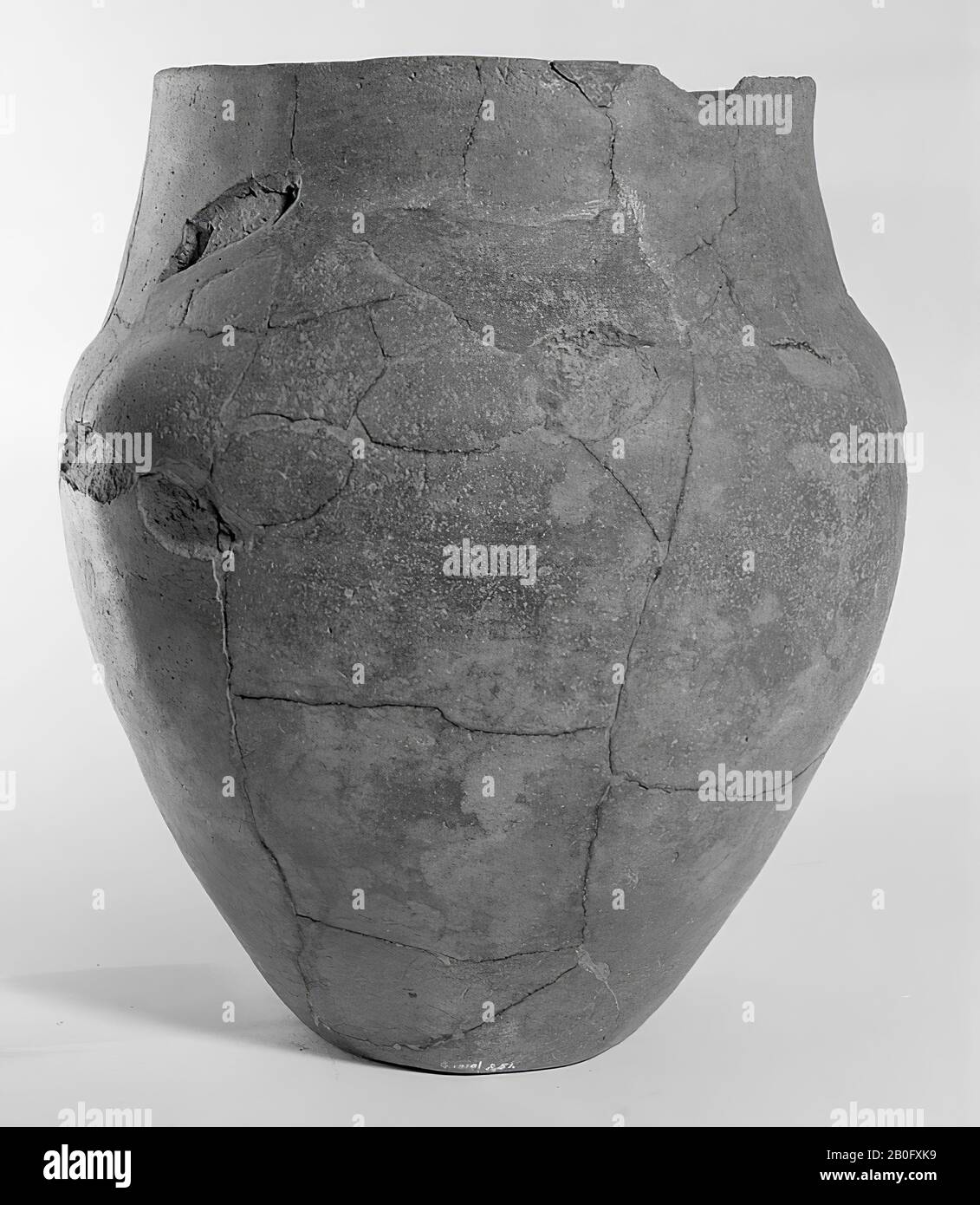 Urna da parete alta e liscia, con spalla debolmente indicata e collo cilindrico. Alcuni grandi incollaggi e aggiunte, scheggiature dal bordo, qualche grande scheggiatura dalla parete, varie crepe nella superficie, circa 20 scheggiature allentate. Contiene residui cremati, urna, terracotta, h: 26 cm, diam: 22,5 cm, preistoria -1200 Foto Stock