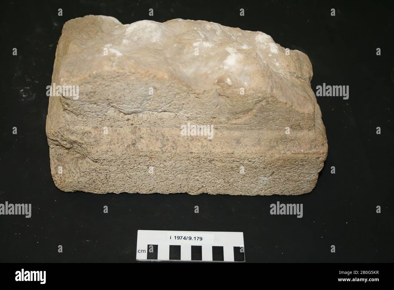 Angolo inferiore destro di un altare. Calcare. Tutto intorno, ci è un plinto che è più largo e più profilato sulla parte anteriore che sui lati e sul retro. Sul lato, è visibile il fondo di un ornamento scolpito., Altare, frammento, pietra, calcare, 17 x 20,5 x 26 cm, romano 150-250, i Paesi Bassi, Zelanda, Noord-Beveland, Colijnsplaat, Oosterschelde Foto Stock