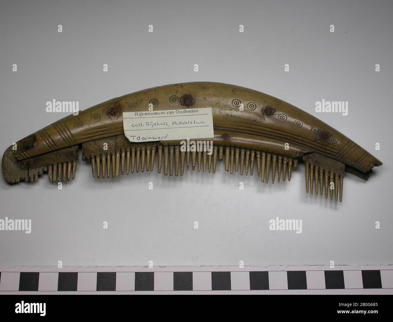 Pettine a tre strati su un lato. Tipo: 'Pettine con quattro piastre di impugnatura collegate'. Questo tipo è dotato di due lame più grandi e due più piccole e strette su entrambi i lati. Le piccole maniglie strette sono chiamate "scatti". Decorazione: Lame maniglia: Cerchi e linee a punti. Entrambi sono decorati in modo identico. Forma: Il pettine ha una dimensione abbastanza grande. Le lame dell'impugnatura sono spesse. Il pettine è ad arco. Piastre denti: 7. Piastre terminali: 1. Numero d'ordine delle targhe dei denti: 9. Denti: 55, alcuni in parte rotti Foto Stock