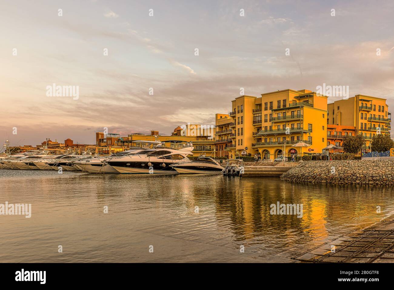 Yacht a motore con spazio per copia all'ancora al tramonto con cielo arancione all'ingresso della nuova Marina, el Gouna, Egitto, 17 gennaio 2020 Foto Stock