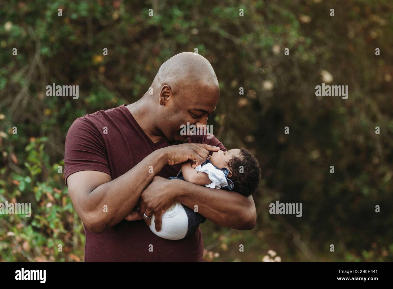 Primo piano su padre felice che tiene e sorridente al neonato Foto Stock