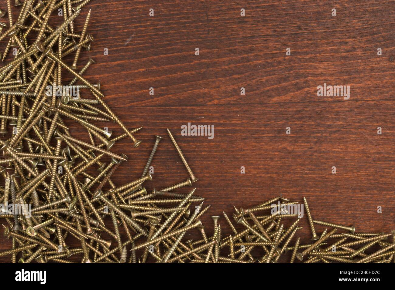 Viti autofilettanti in acciaio, vite in metallo, vite in ferro, vite cromata. Avvitare la forma del telaio su uno sfondo in legno Foto Stock