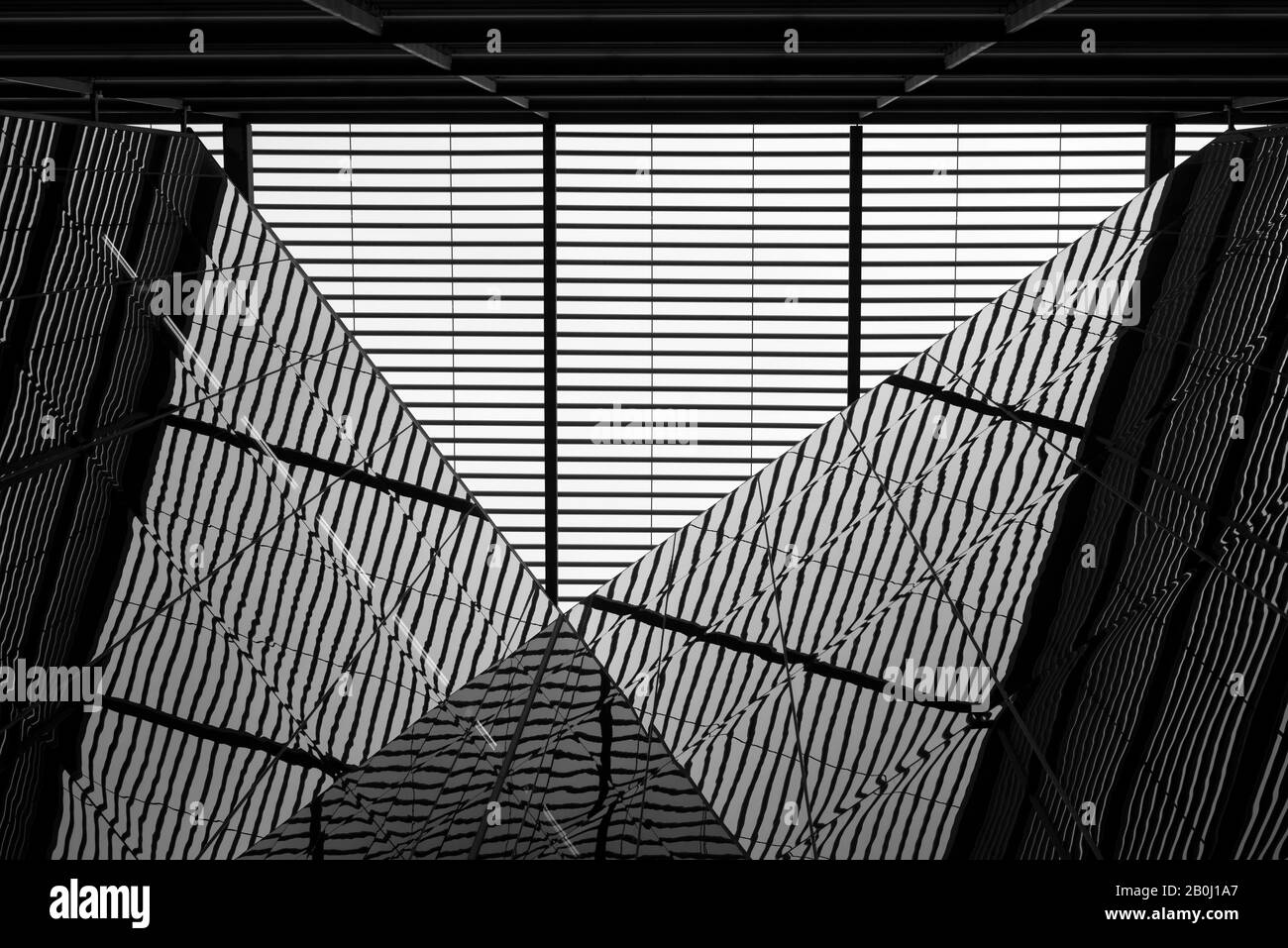 Architettura moderna astratta vista prospettica a basso angolo di una facciata astratta in vetro specchiato che riflette come concetto di composizione simmetrica surreale. Foto Stock