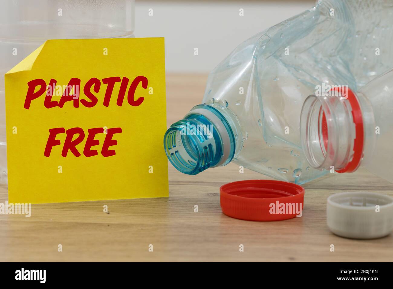 Bottiglie di plastica e una carta gialla con le parole 'senza plastica' il concetto di ridurre la quantità di uso di plastica per la cura dell'ambiente Foto Stock