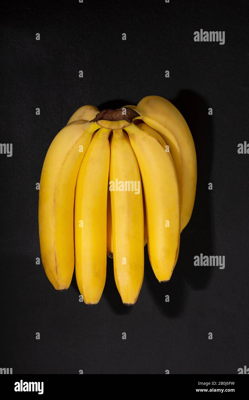 banana marcio, banane baby, pietra di cemento, frutta tropicale, sfondo di pietra, naturale tropicale, dolcificante naturale Foto Stock