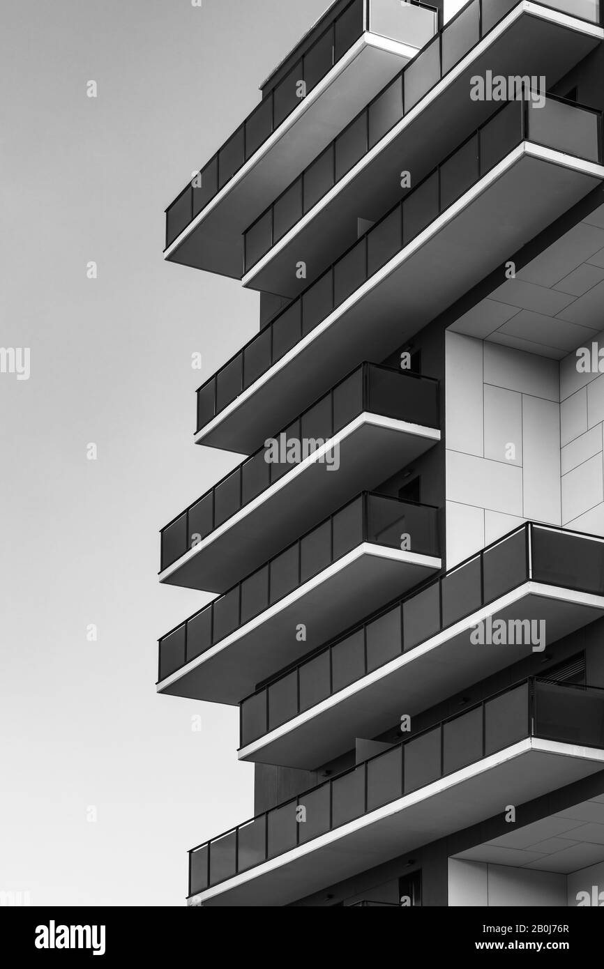 Vista geometrica di una facciata di un edificio residenziale piena di balconi in bianco e nero Foto Stock