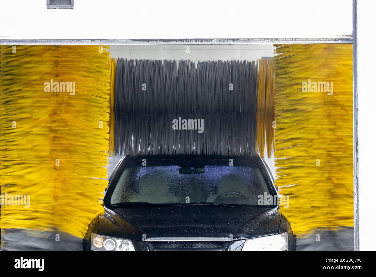L'auto viene lavata in un autolavaggio a tunnel automatico con spazzole ad  alta velocità Foto stock - Alamy