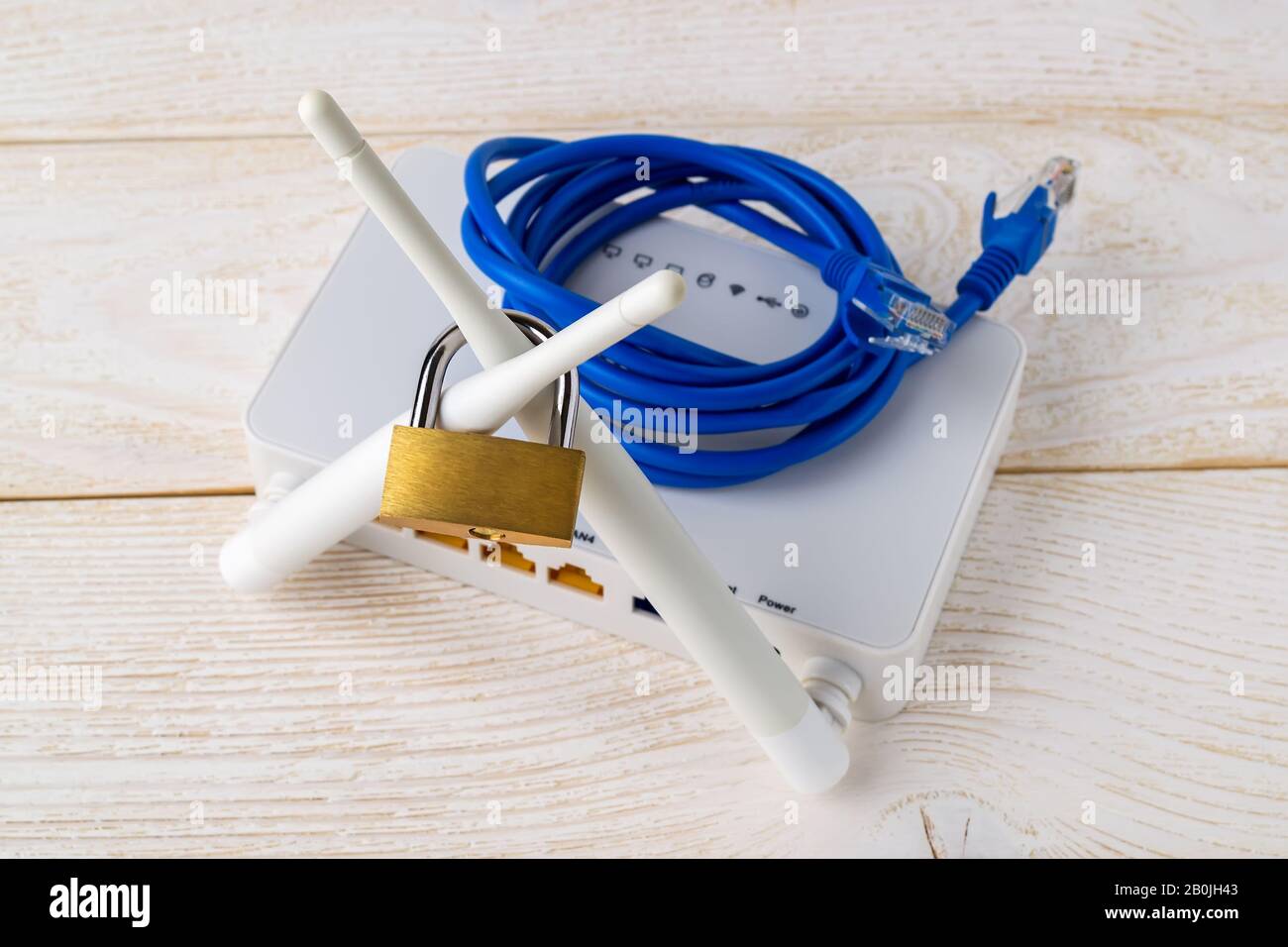 Lucchetto sulle antenne del router wireless Wi-Fi e cavo di rete scollegato su un tavolo in legno. Vietata o limitata la censura di Internet e Internet. Foto Stock