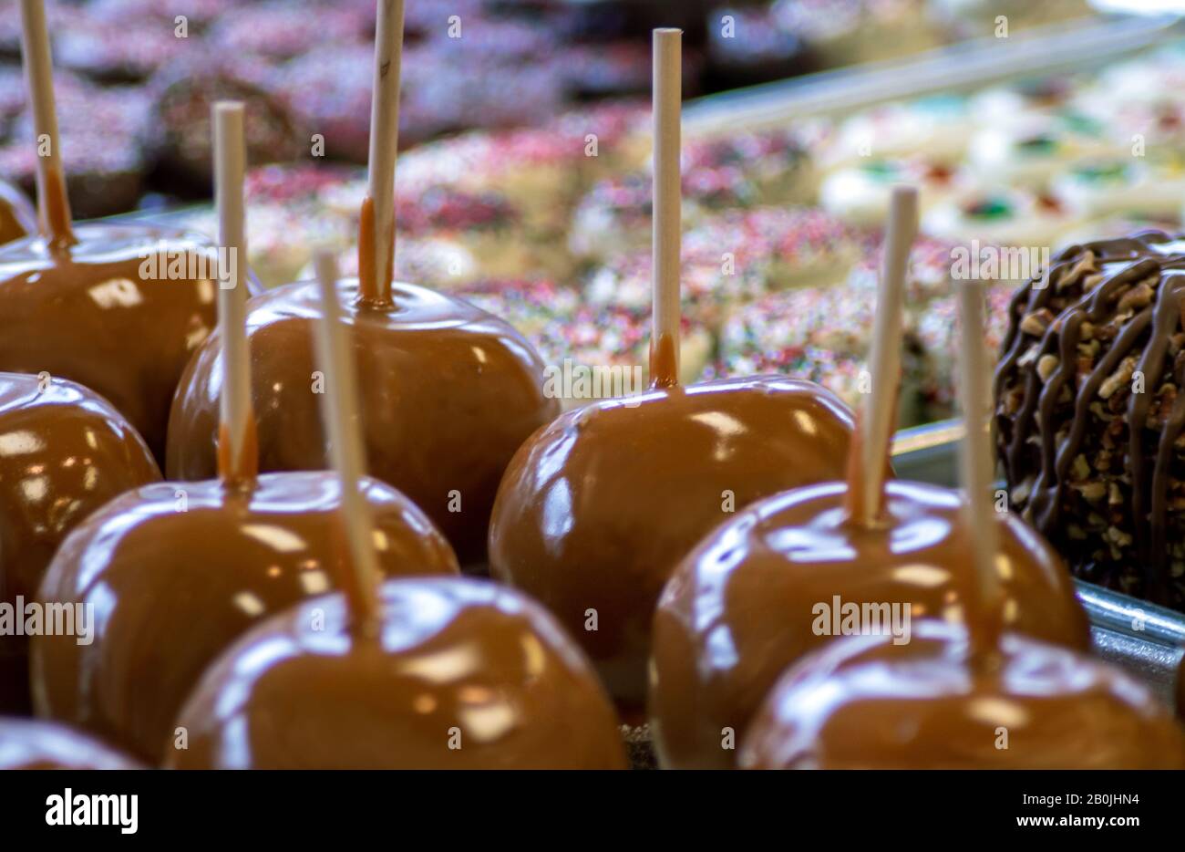 Le mele al caramello e i vassoi di dolcetti sono esposti in un negozio di caramelle Foto Stock