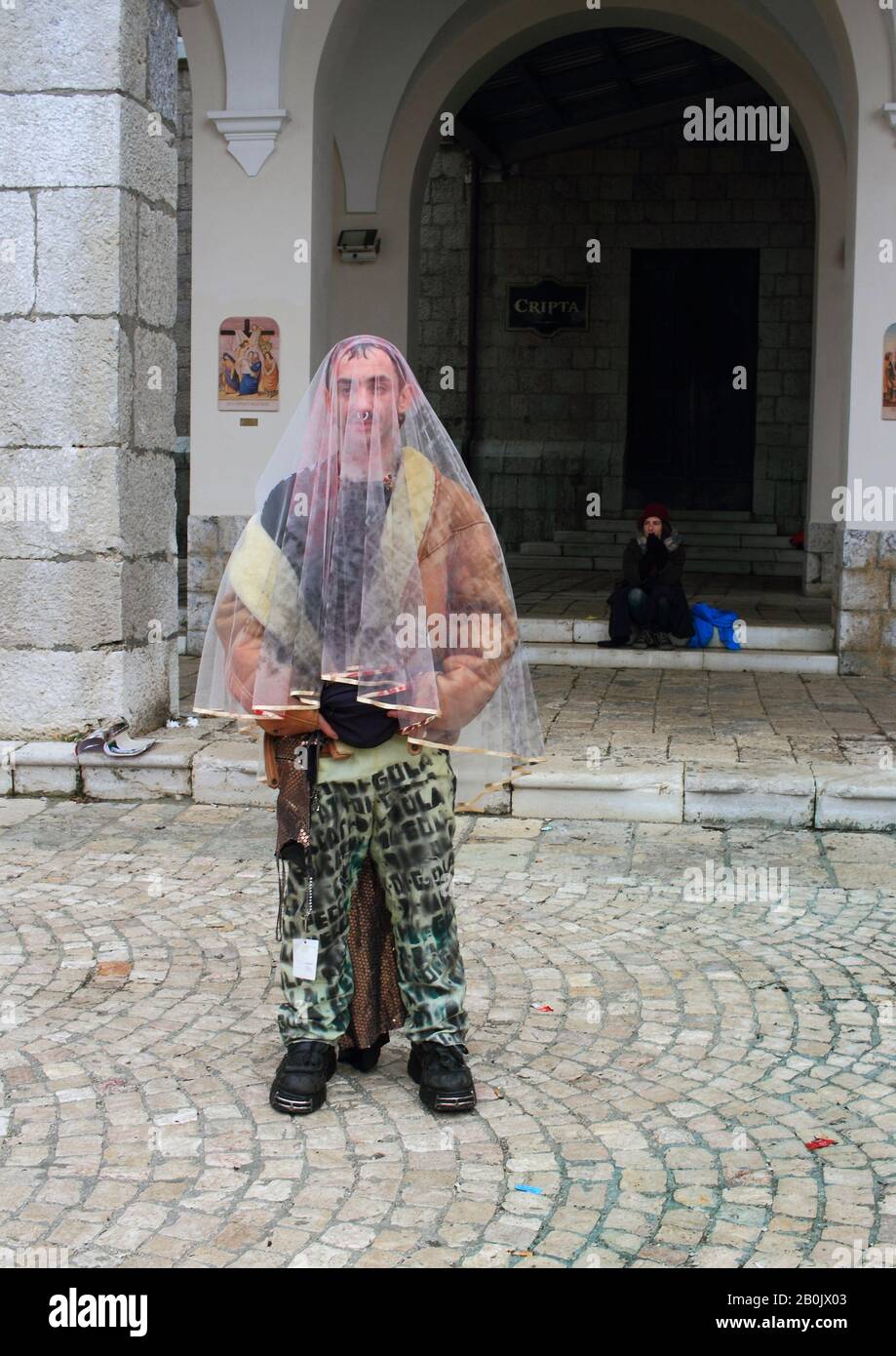 Un fedele con abiti da donna e da uomo in visita alla Madonna di Montevergine . Foto Stock