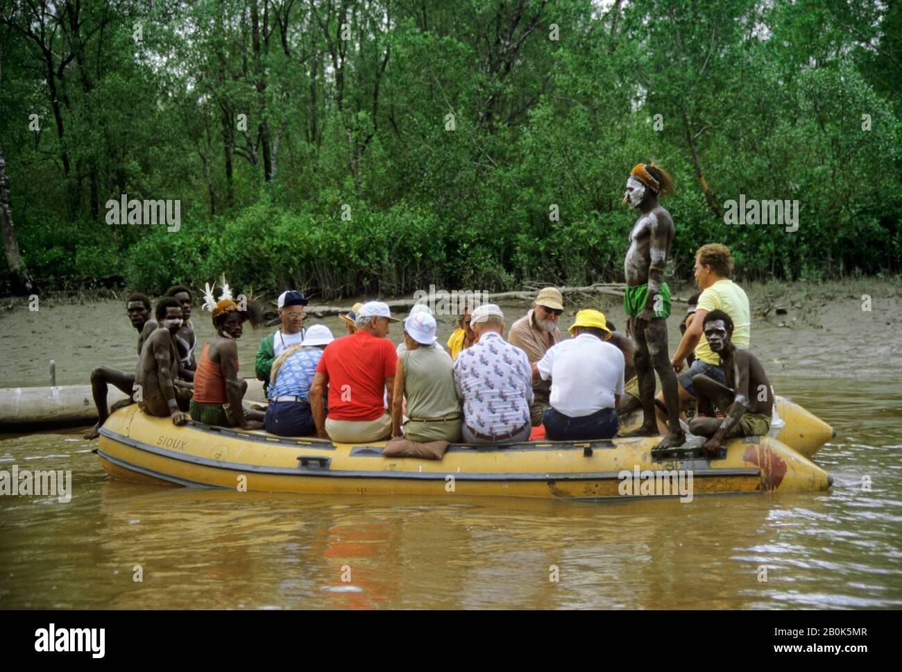 IRIAN JAYA OCCIDENTALE, REGIONE ASMAT, NATIVI E TURISTI IN BARCA DI GOMMA Foto Stock