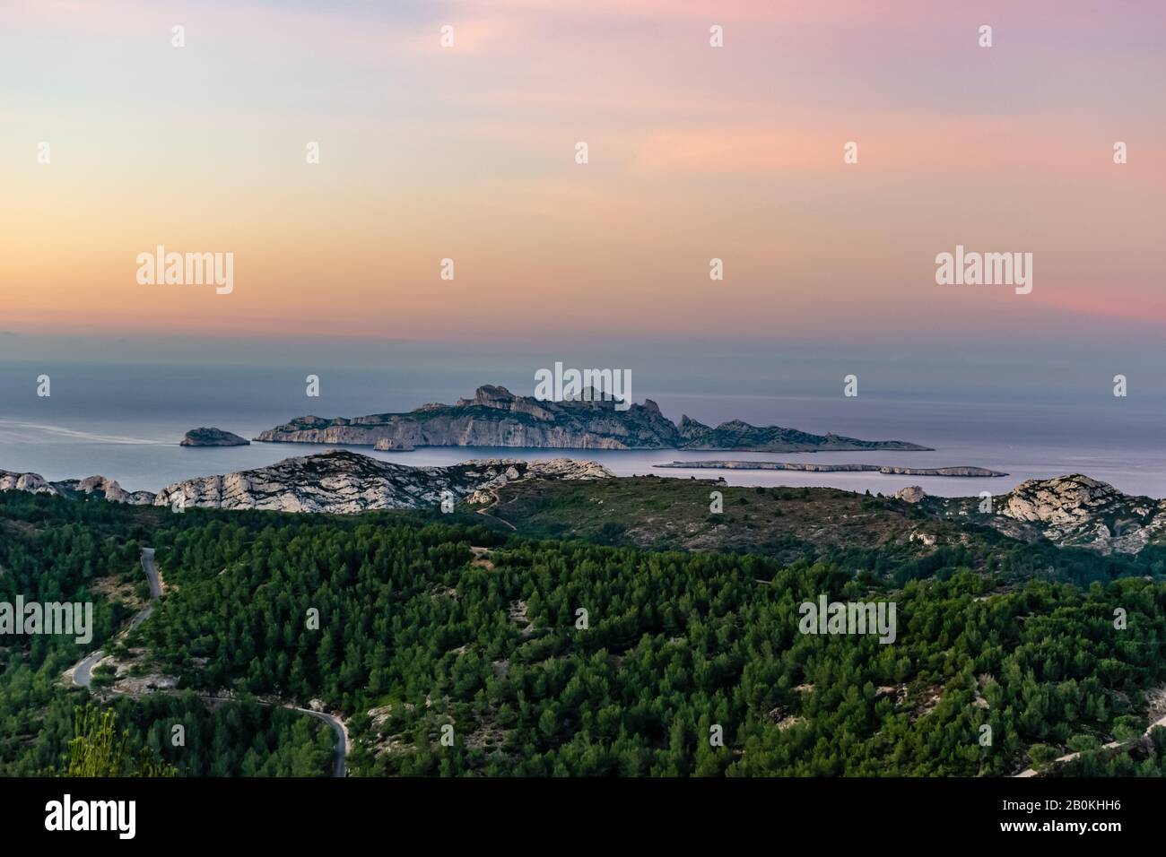 Alba a Calanque de Morgiou (Marsiglia, Francia): La vista mozzafiato della scogliera paesaggio di montagna e l'isola Riou in lontananza sotto il Th Foto Stock