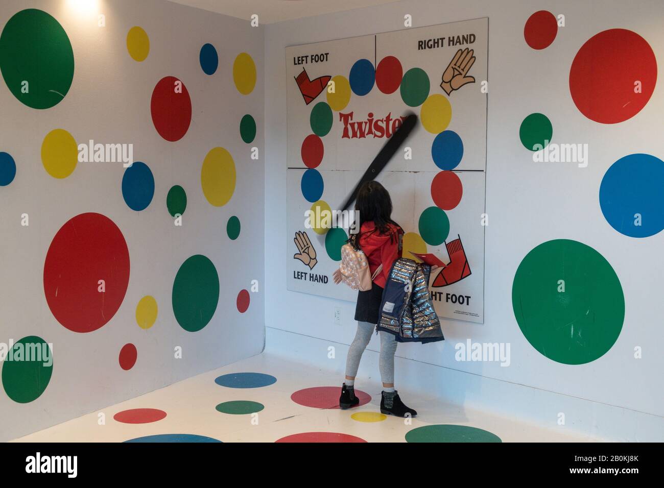 Young Girl Playing in the Giant Twister Game Setup nella Lobby del TWA Hotel , JFK, NYC, USA Foto Stock
