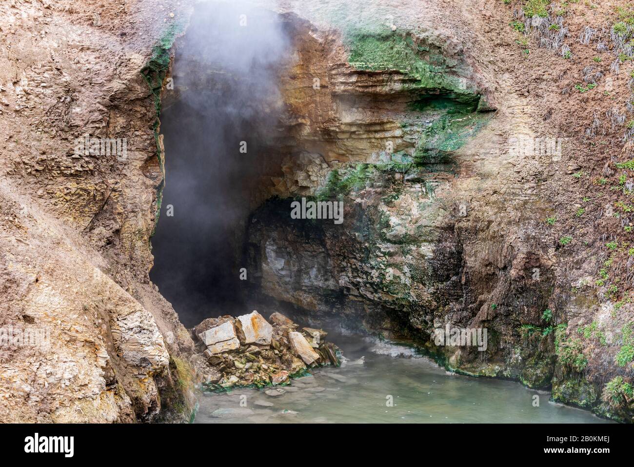 Ingresso alla grotta con vapore e gas in uscita. Sorgente termale all'ingresso della grotta. Foto Stock