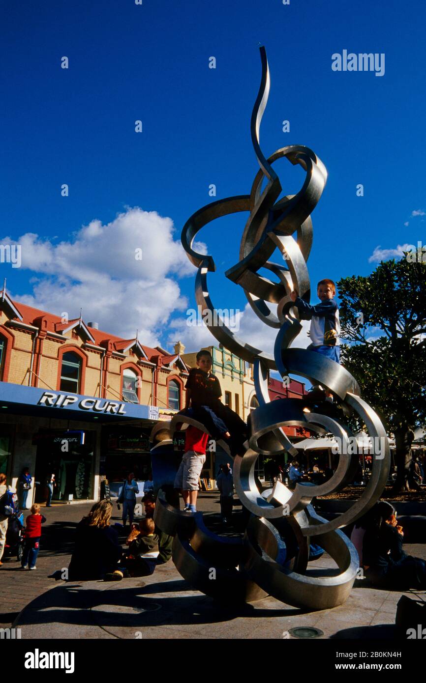 AUSTRALIA, VICINO A SYDNEY, MANLY, PEDONALE STREET, PERSONE, RAGAZZI CHE ARRAMPICANO SULLA SCULTURA Foto Stock