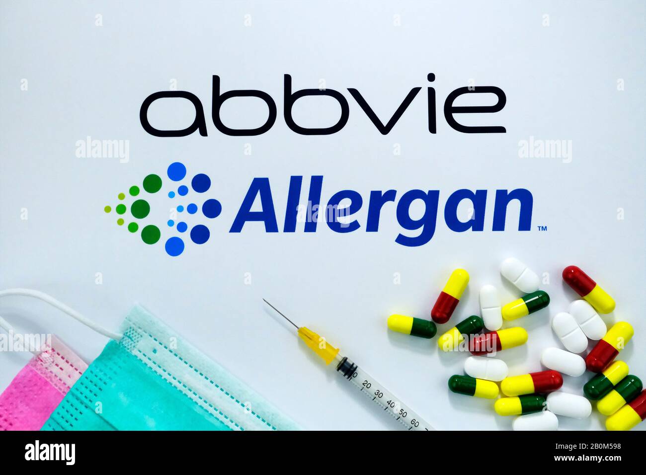 Logo Abbvie e Allergan su brochure con maschere virali, siringhe e pillole. Concetto di fusione delle imprese. Foto Stock