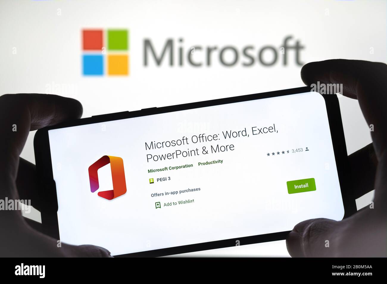 L'app MS Office sullo smartphone tiene le mani e il logo Microsoft sullo sfondo sfocato. Foto reale, non un montaggio. Foto Stock